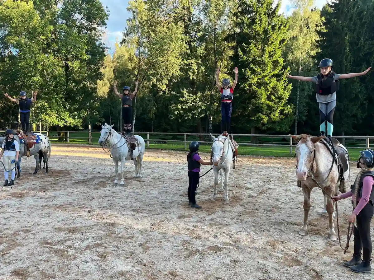 Skupina dětí stojící na koních